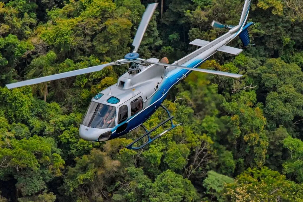 Helicóptero Esquilo AS350 B2 em voo sobre a mata
